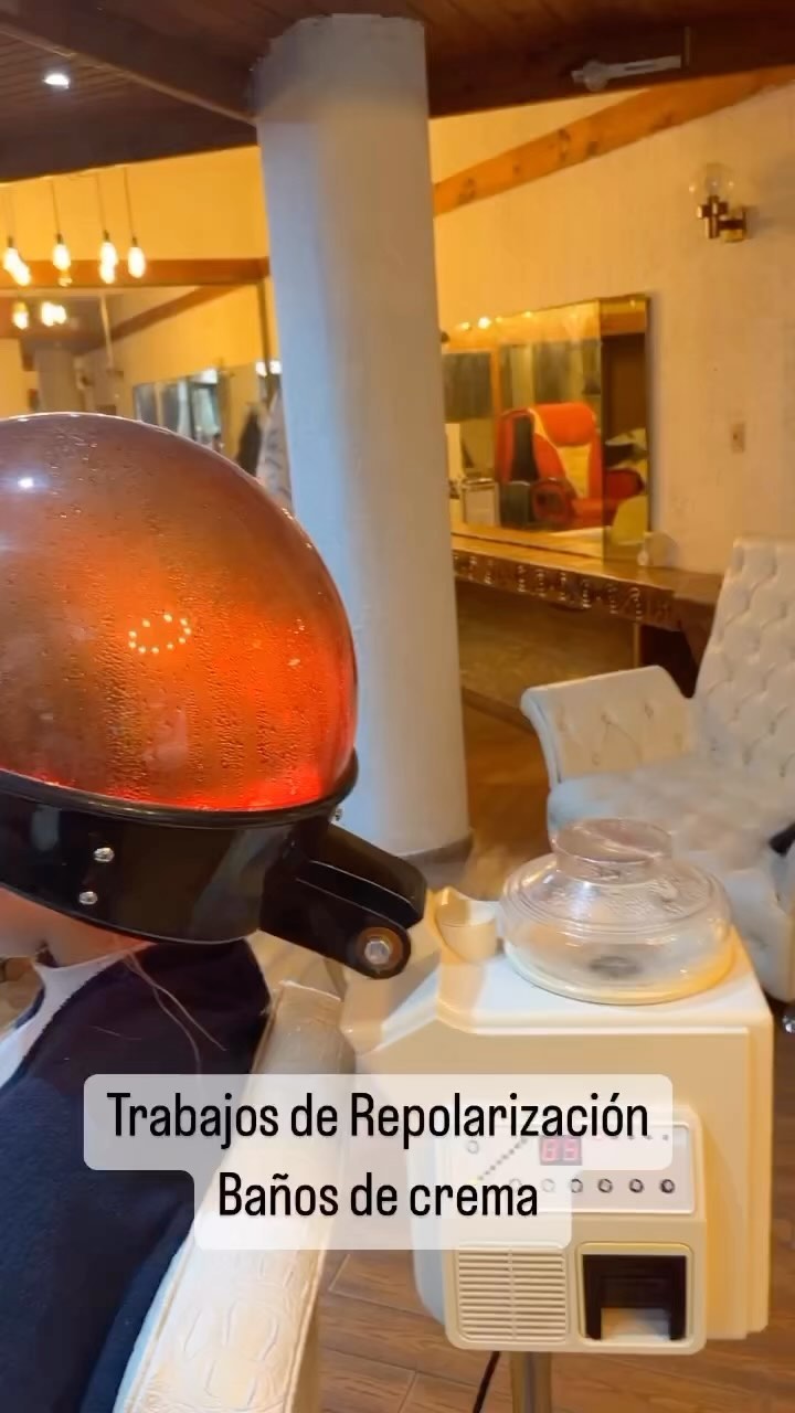 Baño de crema con vaporizador en el salón, junto a un sillón capitoné y un espejo con marco