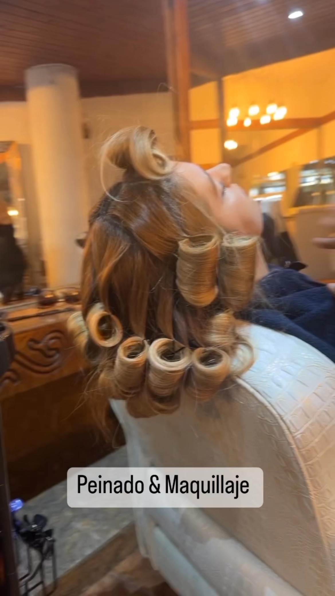 Clienta con ruleros en el salón de Centro Estético Tzur, bajo el techo de madera y la luz cálida
